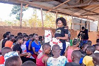 GLM Founder Gailey Mwesigwa speaking to a group of young women and providing feminine hygiene products