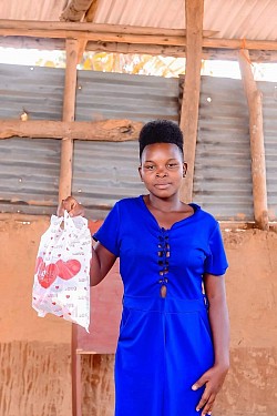 Young lady holding her provisions of feminine hygiene products, from Goshen Ladies Ministries